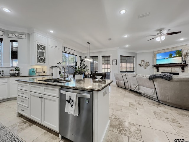 kitchen featuring white cabinetry, stainless steel dishwasher, pendant lighting, dark stone counters, and a kitchen island with sink