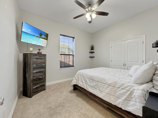 carpeted bedroom featuring ceiling fan and a closet