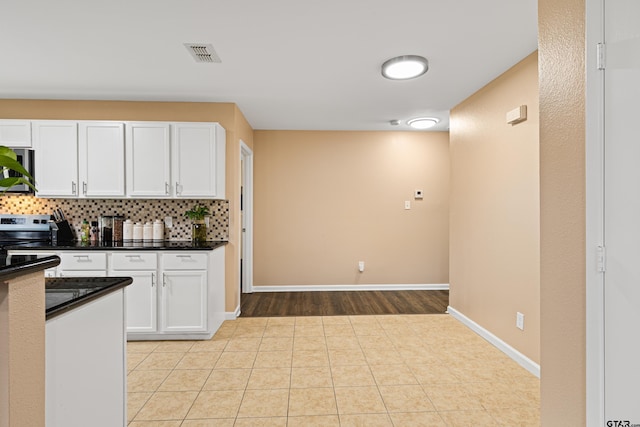 553 Princess Pl, Tyler, TX 75704 - kitchen featuring stainless steel appliances, white cabinets, and dark countertops