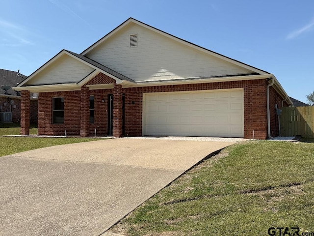 553 Princess Pl, Tyler, TX 75704 - single story home with concrete driveway, brick siding, a garage, and a front lawn
