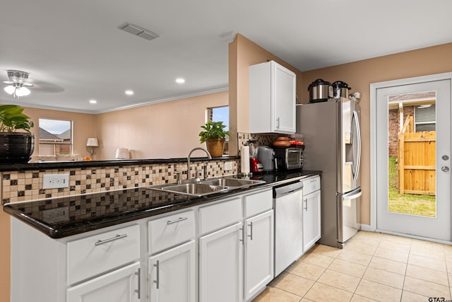 553 Princess Pl, Tyler, TX 75704 - kitchen with visible vents, a sink, appliances with stainless steel finishes, dark countertops, and backsplash