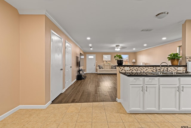 553 Princess Pl, Tyler, TX 75704 - kitchen with crown molding, a ceiling fan, a sink, dark countertops, and baseboards