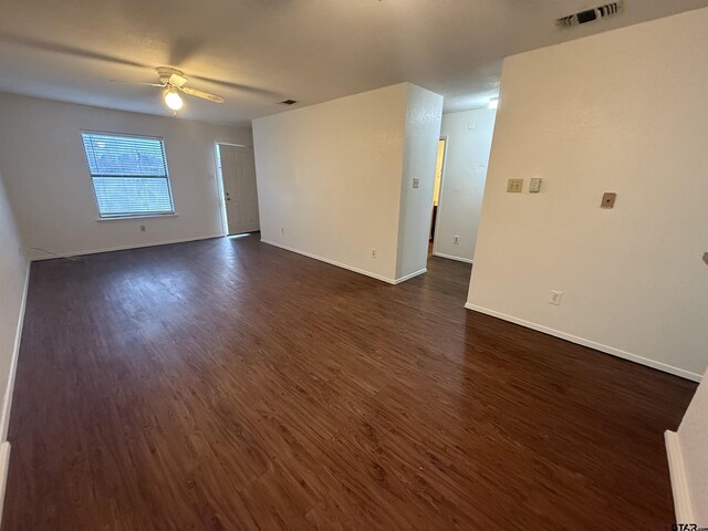 empty room with ceiling fan and dark wood-type flooring