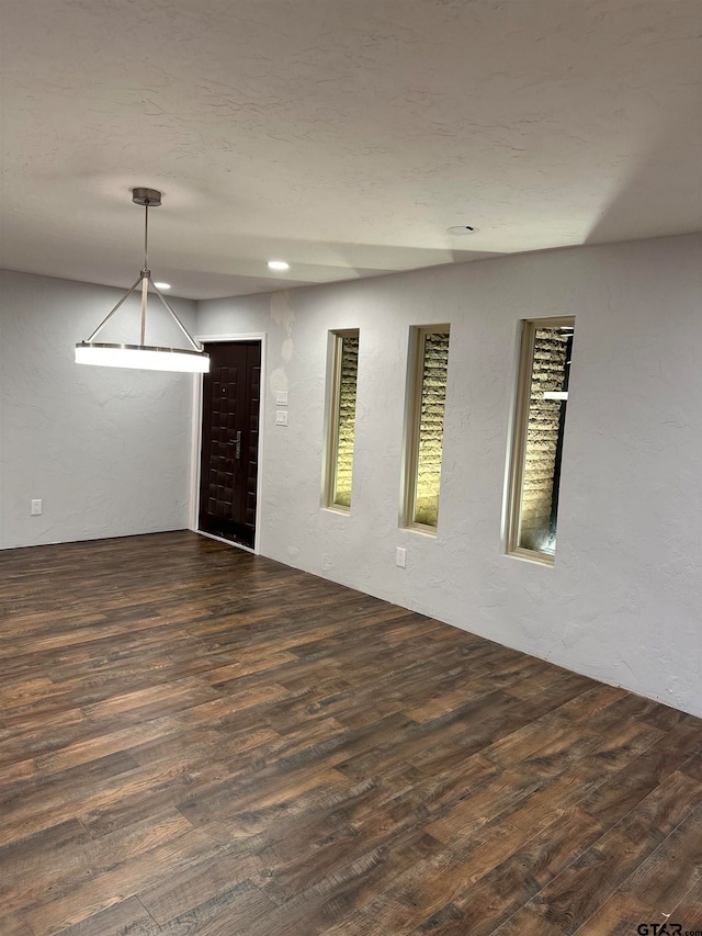 empty room with dark hardwood / wood-style flooring