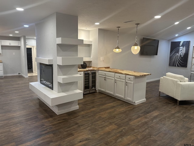 kitchen featuring white cabinets, decorative light fixtures, dark wood-type flooring, and wine cooler