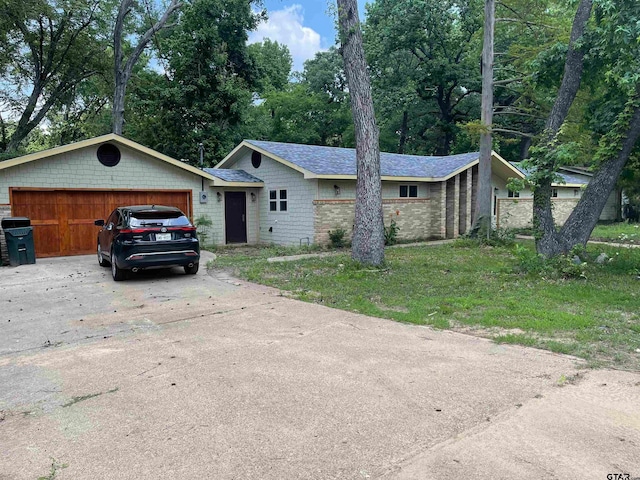 single story home featuring a garage and a front lawn