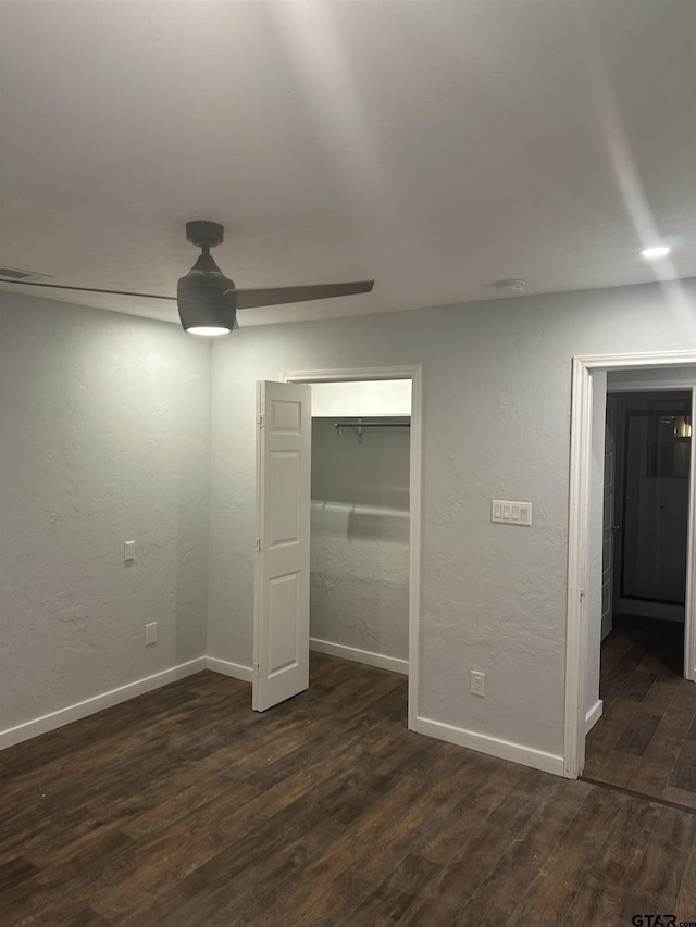 unfurnished bedroom featuring ceiling fan, dark hardwood / wood-style flooring, and a closet