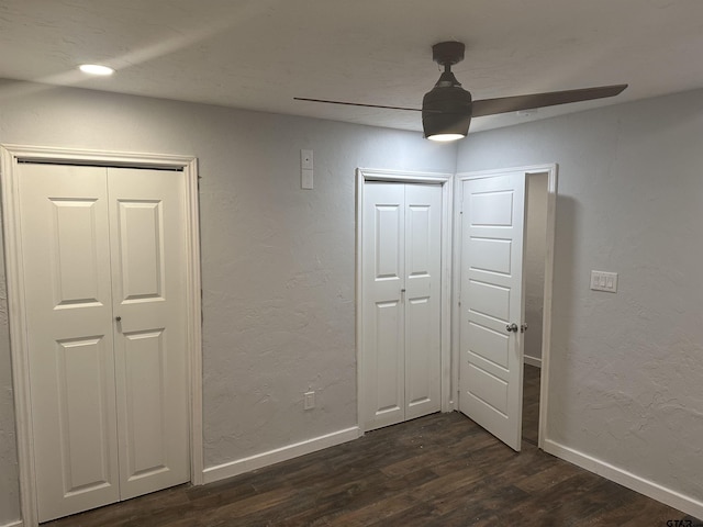 unfurnished bedroom featuring ceiling fan and dark hardwood / wood-style flooring