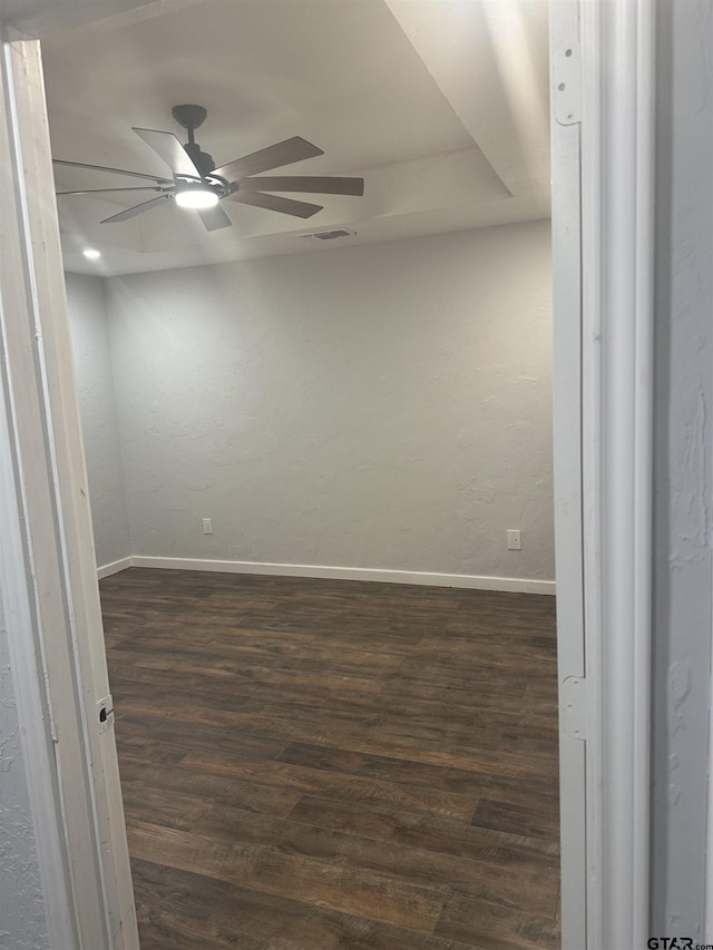 spare room featuring dark hardwood / wood-style flooring and ceiling fan