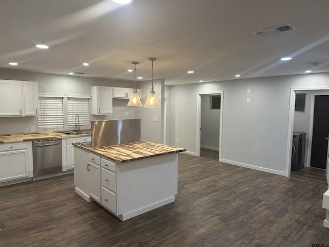 kitchen featuring stainless steel dishwasher, butcher block countertops, decorative light fixtures, a kitchen island, and white cabinetry