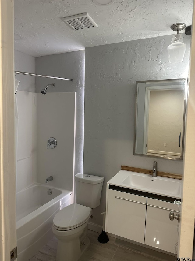 full bathroom with vanity, toilet, washtub / shower combination, and a textured ceiling