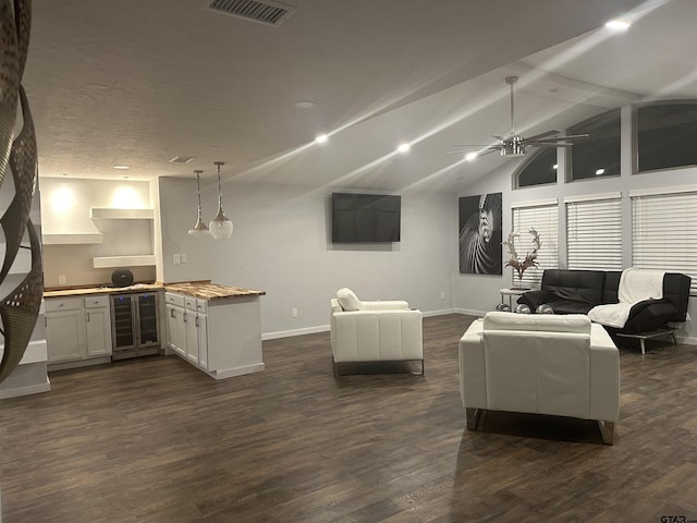 living room featuring wine cooler, dark hardwood / wood-style floors, and vaulted ceiling