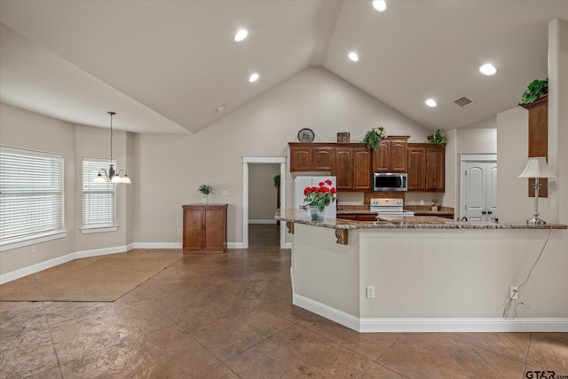 kitchen featuring light stone countertops, a kitchen breakfast bar, white range oven, a chandelier, and decorative light fixtures