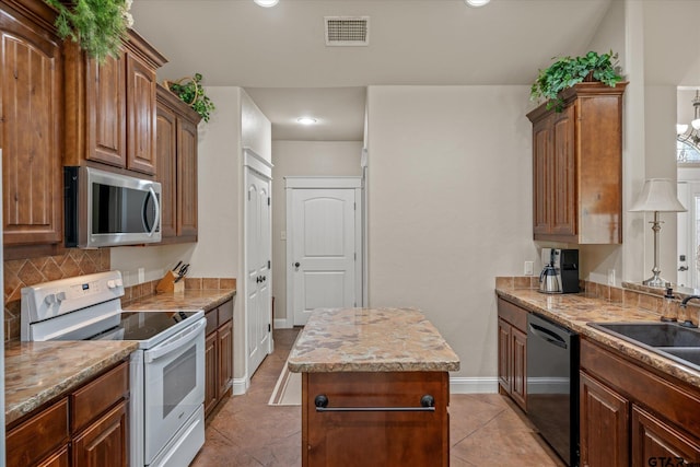 kitchen featuring a center island, light tile patterned flooring, sink, and appliances with stainless steel finishes