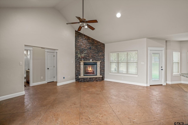 unfurnished living room with light tile patterned floors, high vaulted ceiling, ceiling fan, and a stone fireplace