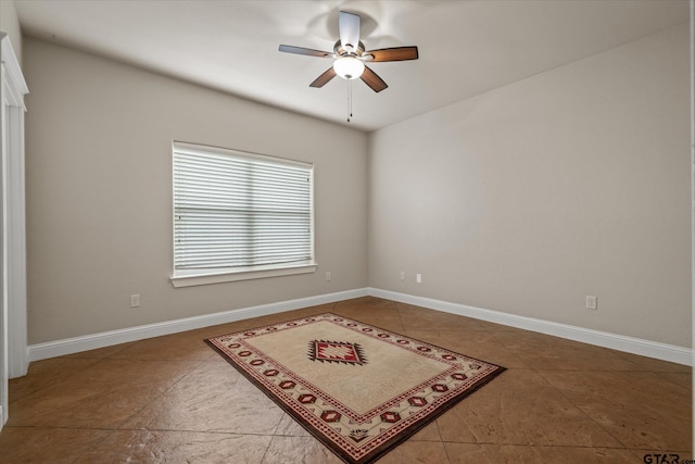 tiled spare room with ceiling fan