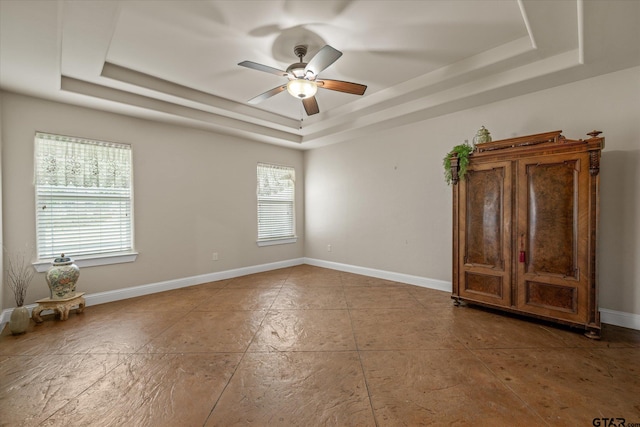 spare room featuring a tray ceiling and ceiling fan