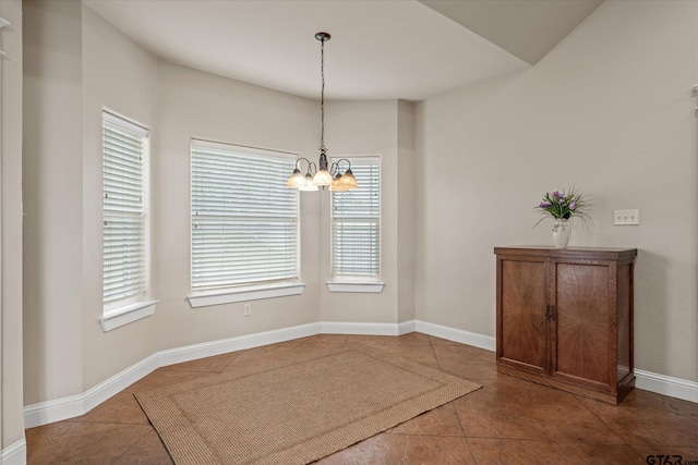 unfurnished dining area with tile patterned floors and an inviting chandelier