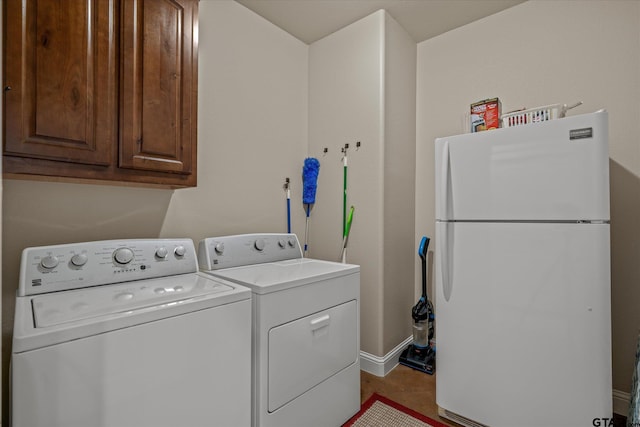 laundry area featuring washing machine and dryer, light tile patterned floors, and cabinets