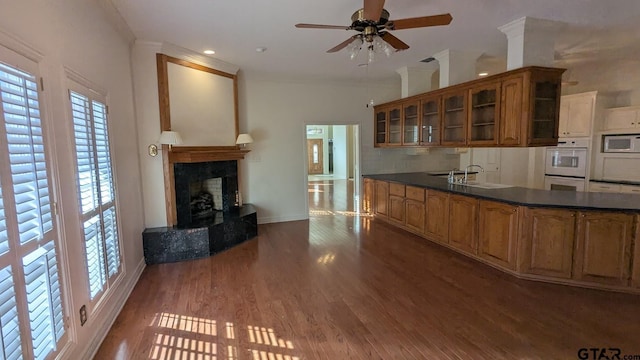 1173 Garden Park Cir, Tyler, TX 75703 - kitchen with built in microwave, a sink, brown cabinets, a ceiling fan, and glass insert cabinets
