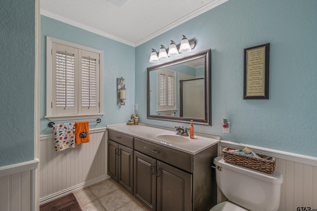 bathroom with toilet, vanity, tile patterned floors, and crown molding