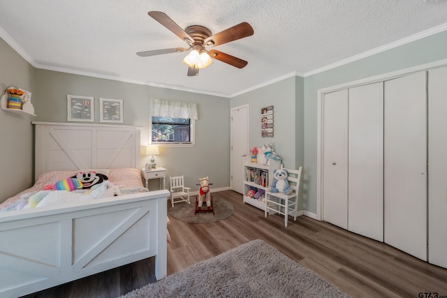 bedroom with a closet, hardwood / wood-style floors, ceiling fan, and crown molding