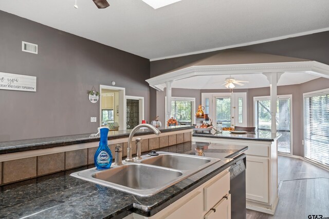 kitchen featuring dishwasher, sink, ceiling fan, white cabinetry, and light wood-type flooring