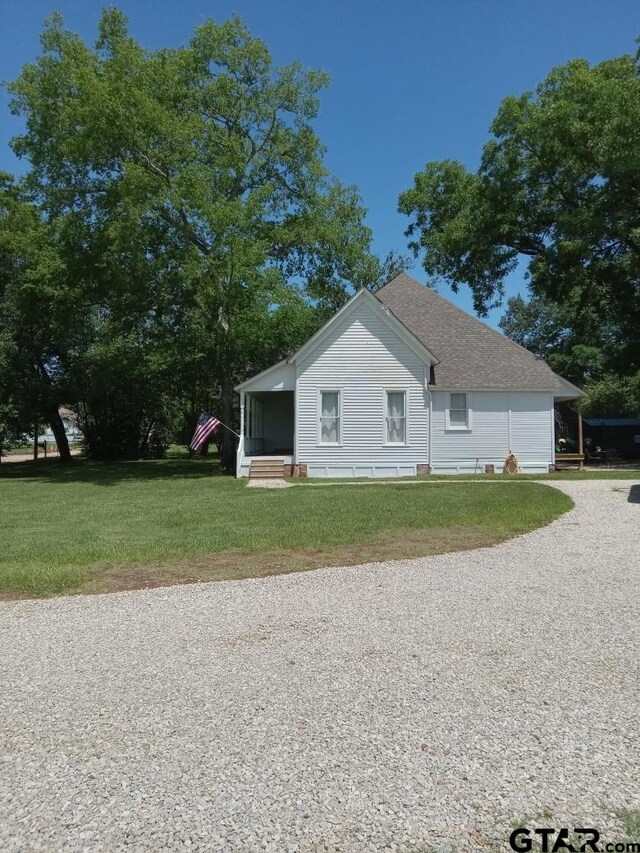 138 S Grace St, Crockett, TX 75835 - view of home's exterior with a lawn, driveway, and roof with shingles
