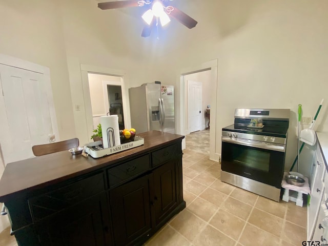 138 S Grace St, Crockett, TX 75835 - kitchen featuring appliances with stainless steel finishes, ceiling fan, dark cabinetry, dark countertops, and light tile patterned floors