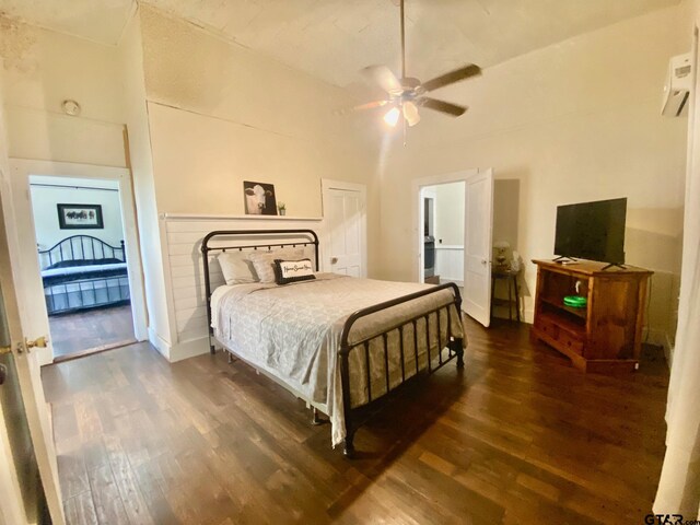 138 S Grace St, Crockett, TX 75835 - bedroom featuring wood finished floors, a wall mounted AC, vaulted ceiling, baseboards, and ceiling fan