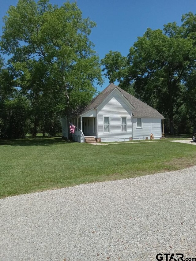 138 S Grace St, Crockett, TX 75835 - view of side of home with a yard and roof with shingles