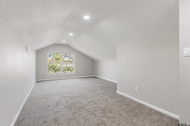 additional living space featuring carpet flooring and lofted ceiling