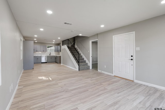 unfurnished living room with light wood-type flooring and sink