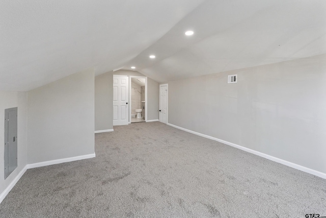 bonus room with carpet flooring, electric panel, and vaulted ceiling