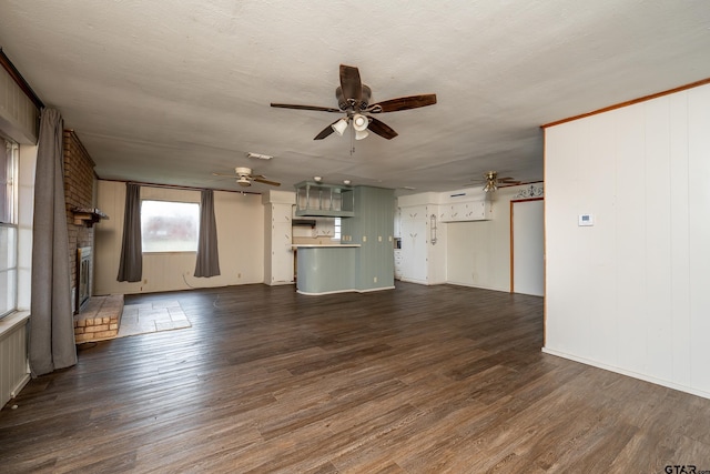 311 S Houston St, Bullard, TX 75757 - unfurnished living room with ceiling fan, a brick fireplace, a textured ceiling, and dark hardwood / wood-style flooring