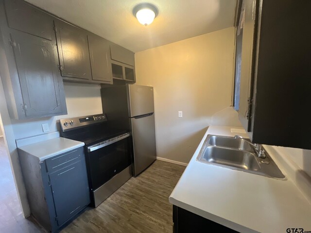 314 S Center St, Longview, TX 75601 - kitchen with stainless steel appliances, a sink, dark wood-style floors, and light countertops