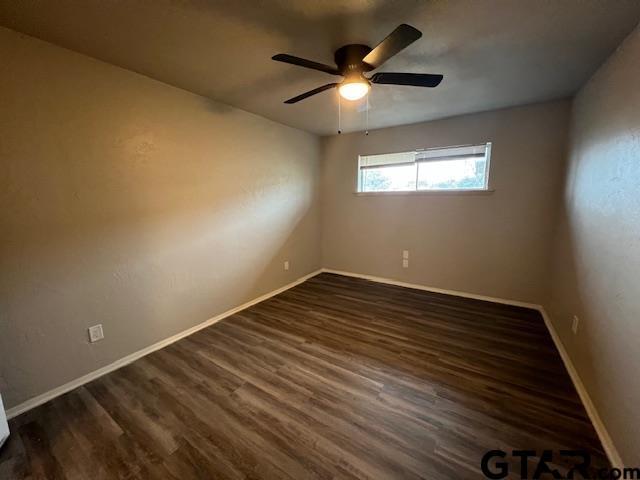 314 S Center St, Longview, TX 75601 - spare room featuring dark wood finished floors, baseboards, and ceiling fan