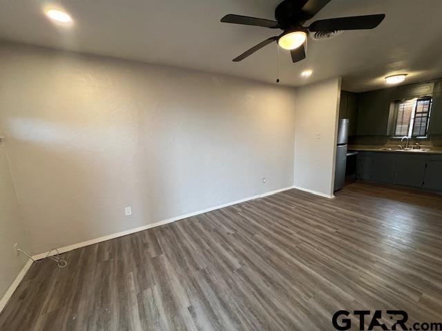 314 S Center St, Longview, TX 75601 - unfurnished living room with baseboards, dark wood finished floors, a ceiling fan, a sink, and recessed lighting
