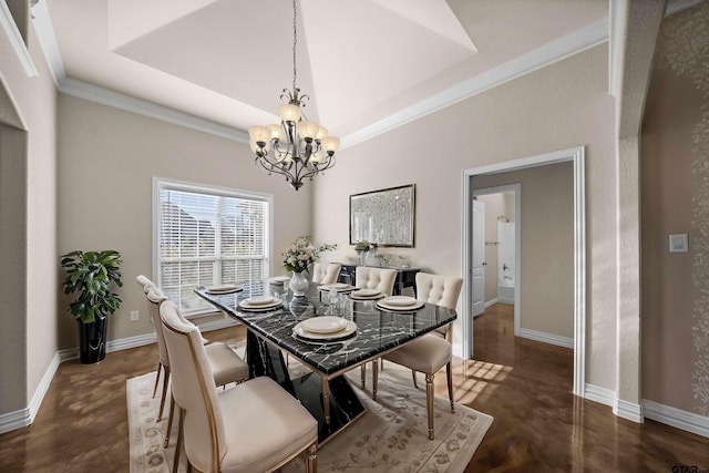 dining space with a raised ceiling, a notable chandelier, and ornamental molding