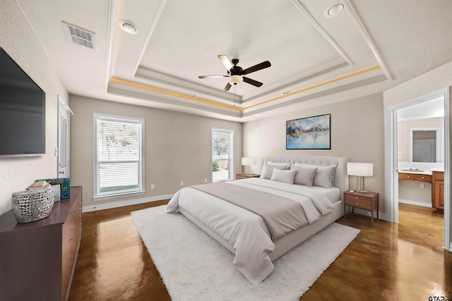 bedroom with ceiling fan, ensuite bathroom, crown molding, and a tray ceiling