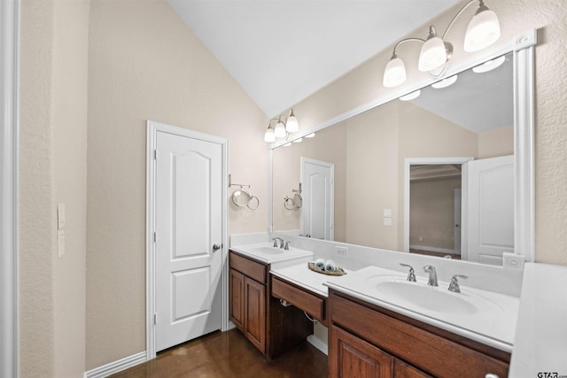 bathroom with vanity, vaulted ceiling, and hardwood / wood-style flooring