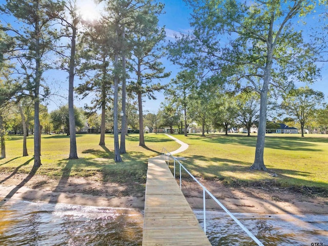 dock area with a yard and a water view