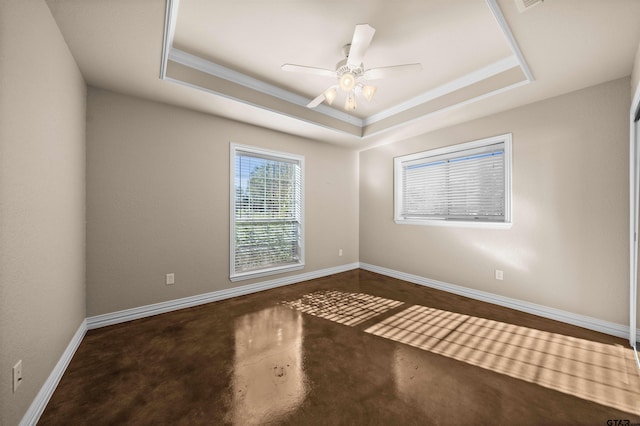 spare room with a tray ceiling, ceiling fan, and ornamental molding