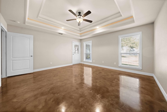 empty room with concrete flooring, a raised ceiling, ceiling fan, and ornamental molding