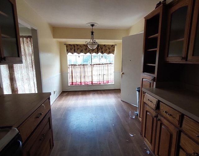 dining area with a wainscoted wall and dark wood-type flooring