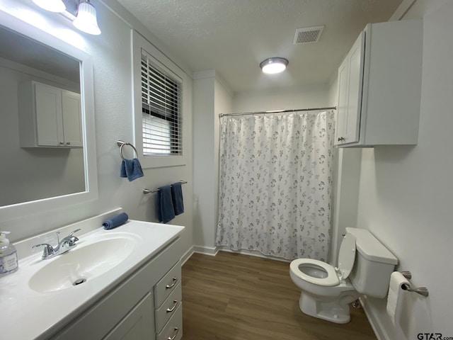 bathroom featuring visible vents, toilet, curtained shower, wood finished floors, and vanity