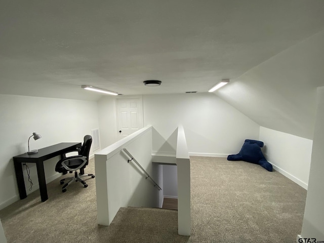 office space with visible vents, baseboards, lofted ceiling, and carpet floors