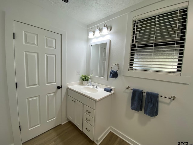 bathroom featuring a textured ceiling, vanity, and wood finished floors