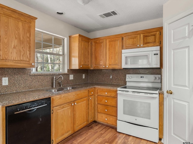 kitchen featuring tasteful backsplash, white appliances, sink, and light wood-type flooring