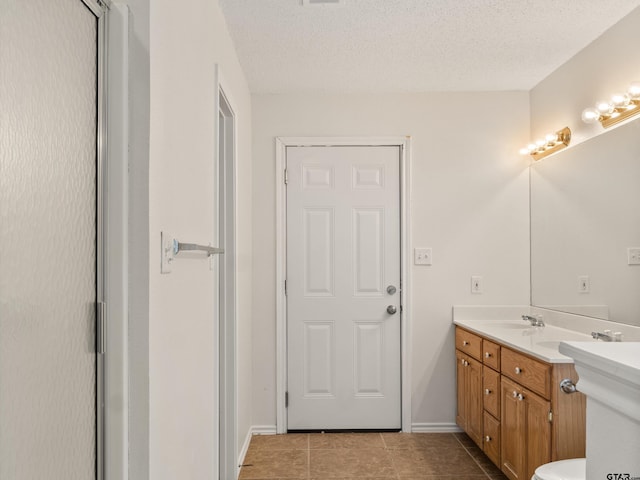 bathroom featuring tile patterned floors, a textured ceiling, and vanity